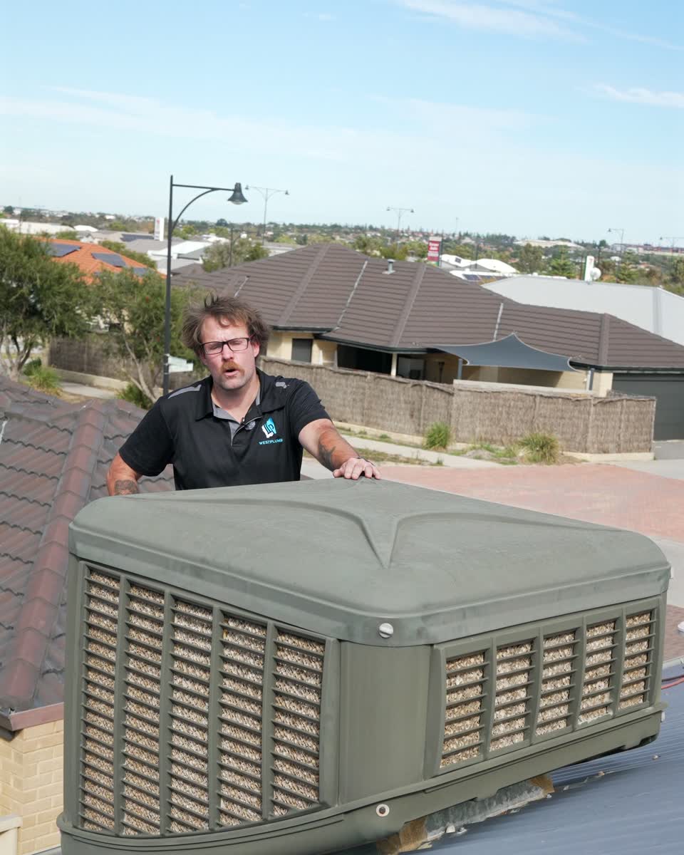 A Westplumb technician behind an evaporative air conditioner
