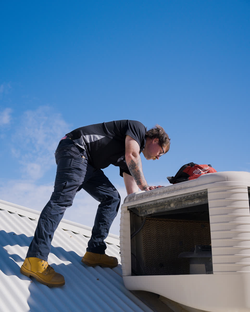 A Westplumb technician working inside an evap unit