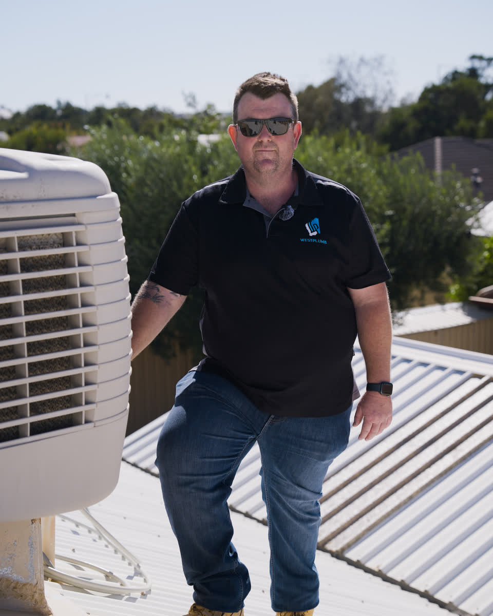 Brent on a roof next to an evaporative air conditioner
